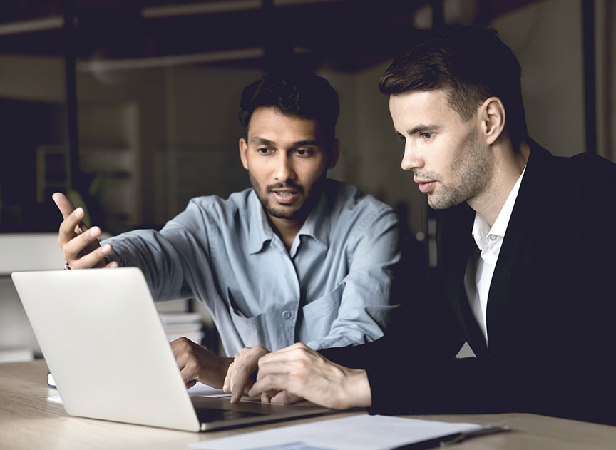 two diverse business men talking at laptop discussing online job inline one